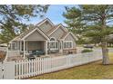 Charming single-story home with a welcoming covered patio, white picket fence, and beautifully landscaped yard at 2295 S Depew St, Denver, CO 80227