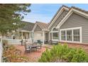 Cozy brick patio area with outdoor seating, barbecue, and covered porch at 2295 S Depew St, Denver, CO 80227