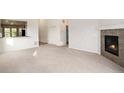 Spacious living room featuring neutral carpet, a tiled fireplace, and an open layout at 5613 S Elk Ct, Aurora, CO 80016