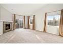 Bright living room with a cozy fireplace, sliding glass door, and ample natural light at 5613 S Elk Ct, Aurora, CO 80016