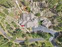 Expansive aerial view of a property featuring a large home, winding driveway, and lush landscaping at 4158 Wild Flower Ct, Evergreen, CO 80439