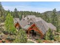 Stunning architectural design highlighting covered patio with wooden beams and a serene mountain backdrop at 4158 Wild Flower Ct, Evergreen, CO 80439