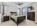 A cozy bedroom features a bed, nightstands, dresser, TV, ceiling fan, and carpeted floors at 12301 Festival Ln, Thornton, CO 80241