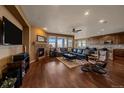 Cozy living room featuring hardwood floors, a fireplace, and an open-concept layout at 15789 W 95Th Pl, Arvada, CO 80007