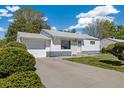 Charming single-story home with a driveway and landscaped front yard at 1211 S Zuni St, Denver, CO 80223