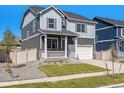 Attractive gray two-story home boasts a charming porch, and well-kept landscaping at 27756 E Byers Pl, Aurora, CO 80018