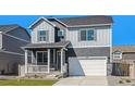 Inviting two-story home with gray siding, a front porch, a two-car garage, and manicured lawn at 27756 E Byers Pl, Aurora, CO 80018