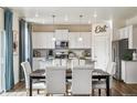 Bright kitchen and dining area featuring white cabinets, stainless steel appliances, and modern decor at 27756 E Byers Pl, Aurora, CO 80018