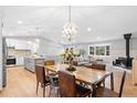 Open-concept dining room with wood table, stylish chairs, and views of the adjacent kitchen and living areas at 18045 Arrowwood Dr, Monument, CO 80132