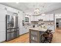 Modern kitchen boasts stainless steel appliances, white cabinets, a granite island, and pendant lighting at 18045 Arrowwood Dr, Monument, CO 80132