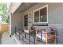 Inviting front porch with cozy seating with a glimpse of trees and street at 3325 Irving St, Denver, CO 80211