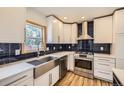 Modern kitchen with stainless steel appliances and dark blue backsplash at 1438 Marion St, Georgetown, CO 80444