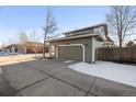 Two-car garage with a concrete driveway and snow on the ground at 16935 Buffalo Valley Path, Monument, CO 80132