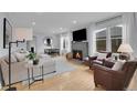 Bright living room featuring hardwood floors, a stone fireplace, and modern decor at 2212 Ingalls St, Edgewater, CO 80214