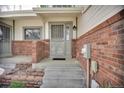 Cozy porch with brick accents and detailed doorway creating a welcoming entrance at 5283 Union Ct # 8, Arvada, CO 80002