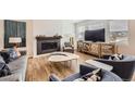 Cozy living room featuring a fireplace, stylish furniture, and ample natural light through the windows at 154 Cortona Pl, Castle Pines, CO 80108