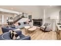 Inviting living room featuring a fireplace, stylish seating, and a staircase at 154 Cortona Pl, Castle Pines, CO 80108