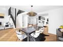 Elegant dining room features modern chandelier and black staircase with wood floors at 5401 E Dakota Ave # 3, Denver, CO 80246