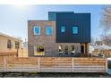 Modern two-story home featuring mixed brick and dark metal exterior, complemented by a stylish wood fence at 3430 W 25Th Ave, Denver, CO 80211