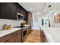 Modern kitchen featuring stainless steel appliances and sleek black and wood cabinets at 3430 W 25Th Ave, Denver, CO 80211
