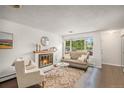 Bright living room with fireplace, large windows, hardwood floors, and stylish decor at 64 Nome Way # A, Aurora, CO 80012