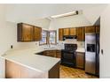 A well-lit kitchen with a skylight, oak cabinets, laminate countertops, and stainless-steel appliances at 16780 E Hialeah Ave, Centennial, CO 80015