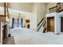 Bright living room featuring vaulted ceilings, a fireplace, and sliding glass doors to the exterior at 16780 E Hialeah Ave, Centennial, CO 80015