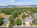 Aerial view featuring well-kept homes, tennis courts, and a backdrop of rolling hills and mature trees at 4059 Nevis St, Boulder, CO 80301
