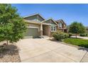 Lovely single-story home with a stone facade, a spacious driveway, and lush green landscaping at 7201 W Asbury Pl, Lakewood, CO 80227