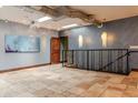 Second-floor hallway featuring travertine floors, industrial ductwork, and staircase at 2150 Curtis St, Denver, CO 80205