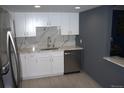 Modern kitchen with white cabinets, stainless steel appliances and marble backsplash and countertops at 14300 E Marina Dr # 109, Aurora, CO 80014