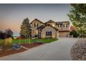 Curved driveway and two-story home with stone exterior at 5268 Talavero Pl, Parker, CO 80134