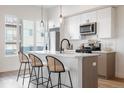 Bright kitchen with white cabinets, island, and stainless steel microwave at 2920 W Parkside Pl, Denver, CO 80221