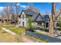 This charming home boasts a well-manicured lawn, mature trees, and a beautifully designed exterior at 1002 Detroit St, Denver, CO 80206