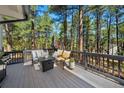 Relaxing outdoor deck area with comfortable seating, perfect for enjoying the peaceful wooded surroundings at 1935 Poncha Ct, Larkspur, CO 80118