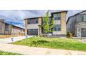 Modern two-story home with well-maintained lawn, a spacious driveway, and lush, young tree at 23708 E 42Nd Ave, Aurora, CO 80019