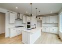 Bright, open kitchen with stainless steel appliances, a center island, and sleek white cabinetry at 23708 E 42Nd Ave, Aurora, CO 80019