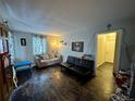 Living room with hardwood floors, couch, and access to hallway at 11856 E 7Th Ave, Aurora, CO 80010