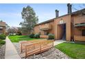 Well-maintained condo exterior with a charming bridge walkway and lush, green landscaping at 3335 S Ammons St # 6-102, Lakewood, CO 80227