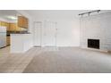 Bright living room featuring neutral carpet, white brick fireplace, and open layout at 3335 S Ammons St # 6-102, Lakewood, CO 80227