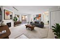 Bright living room featuring a fireplace with white brick, modern art, and a sliding glass door at 3335 S Ammons St # 6-102, Lakewood, CO 80227