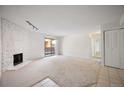 Expansive living room with neutral carpet, fireplace, and sliding glass door at 3335 S Ammons St # 6-102, Lakewood, CO 80227