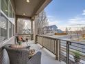 Relaxing front porch features comfortable wicker seating, a coffee table, and a lovely neighborhood view at 5590 W 97Th Ave, Westminster, CO 80020