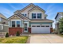 Charming two-story home with brick accents, an attached two-car garage and manicured lawn at 12996 Banyon Cir, Parker, CO 80134