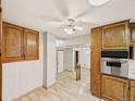 View of kitchen leading to living space; wooden cabinetry and stainless steel appliances at 10951 Rosalie Dr, Northglenn, CO 80233