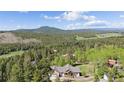 Aerial view of a charming home nestled among trees in a picturesque setting with mountain views at 11033 Barker Ave, Conifer, CO 80433