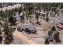 An aerial shot of a residential single-Gathering home situated in a wooded area, offering privacy and a serene setting at 11033 Barker Ave, Conifer, CO 80433