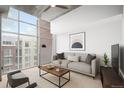 Bright living room featuring large windows, neutral décor, and comfortable seating at 1700 Bassett St # 703, Denver, CO 80202