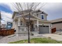 Two-story home featuring a covered porch and a two-car garage, partially obscured by a bare tree in the front yard at 1246 Blackhaw St, Elizabeth, CO 80107