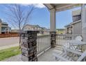 Welcoming front porch with stone pillars, white railing, and chairs, offering a view of the neighborhood at 1246 Blackhaw St, Elizabeth, CO 80107